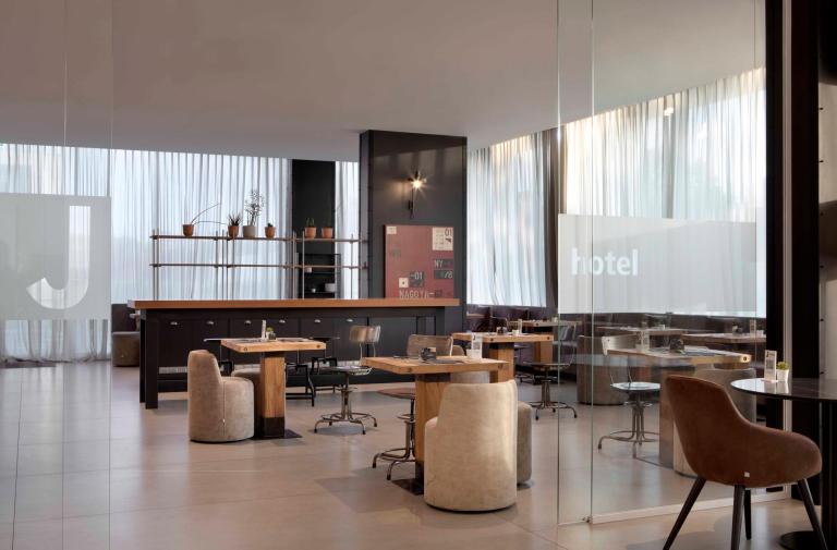 Moderno ristorante d'hotel con arredi eleganti e ampie finestre.