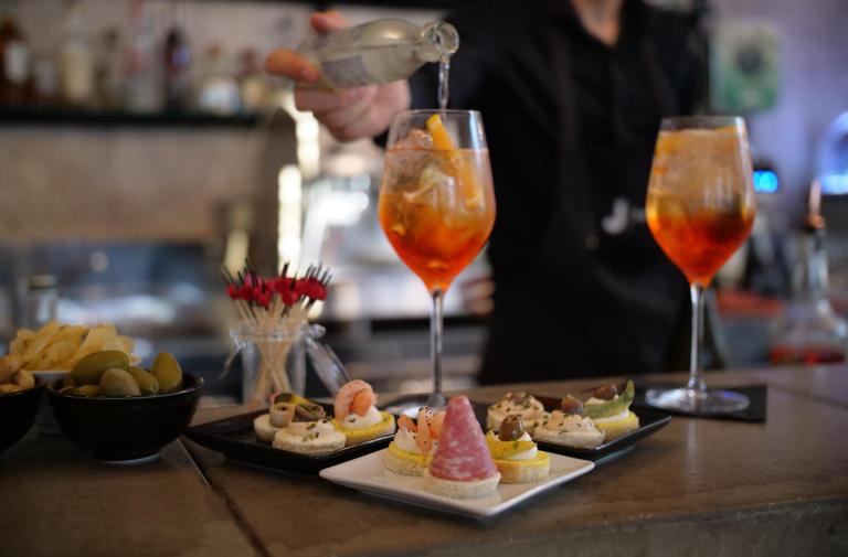 Aperitif with cocktails and snacks in a cozy bar.